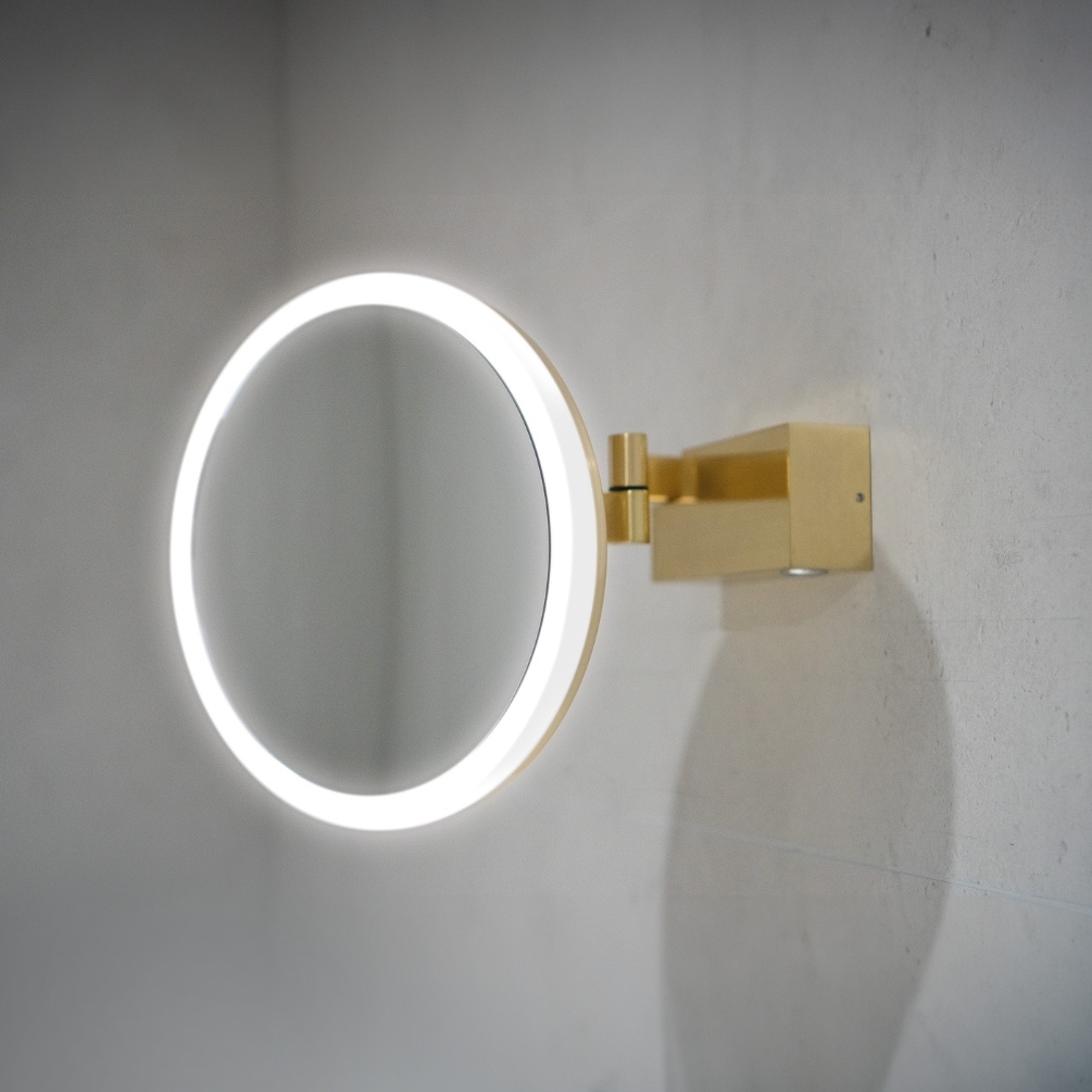 Lifestyle image of the hib. Cirque Brushed Brass LED Magnifying Mirror